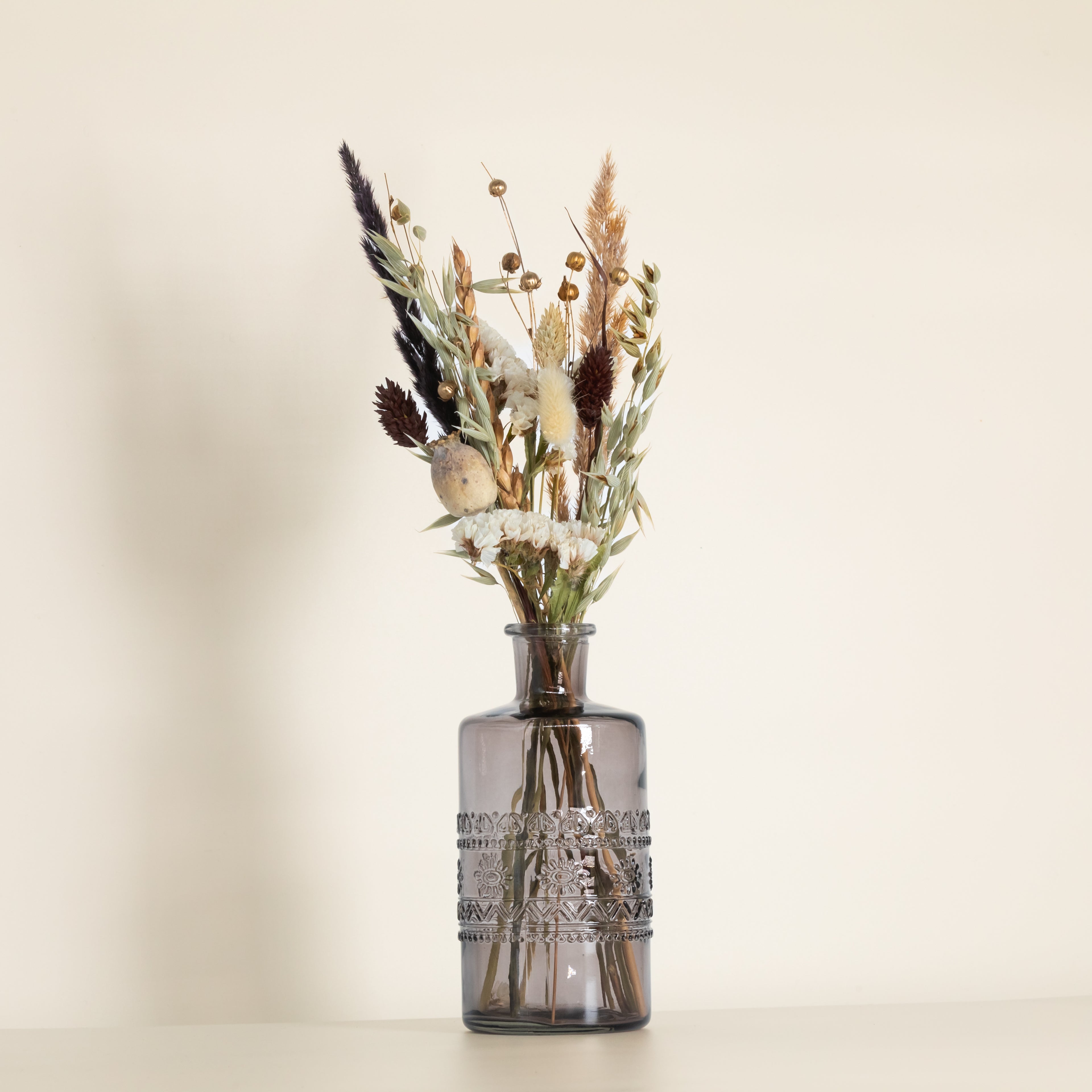 Trockenblumenstrauß in schwarzer Glasvase