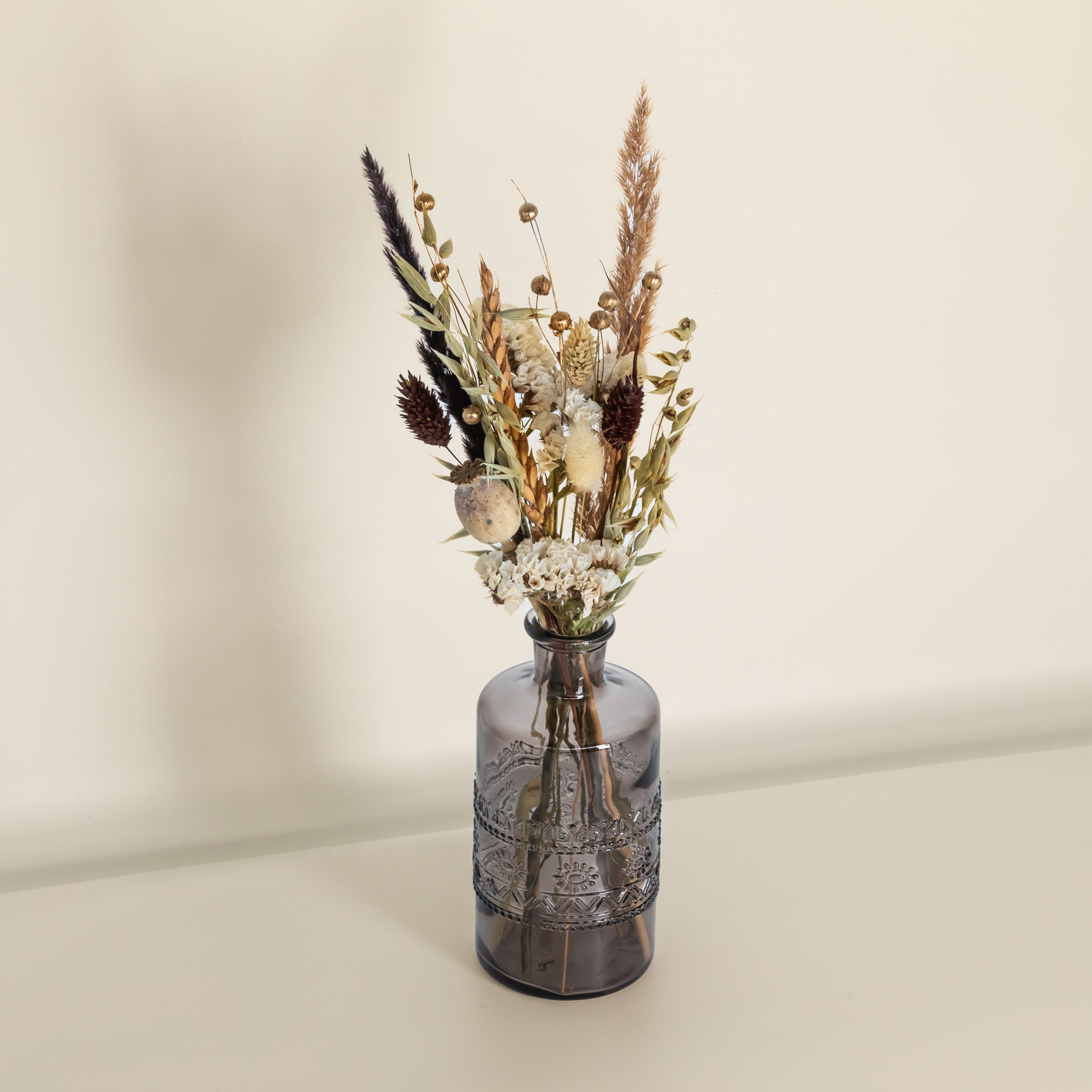 Trockenblumenstrauß in schwarzer Glasvase
