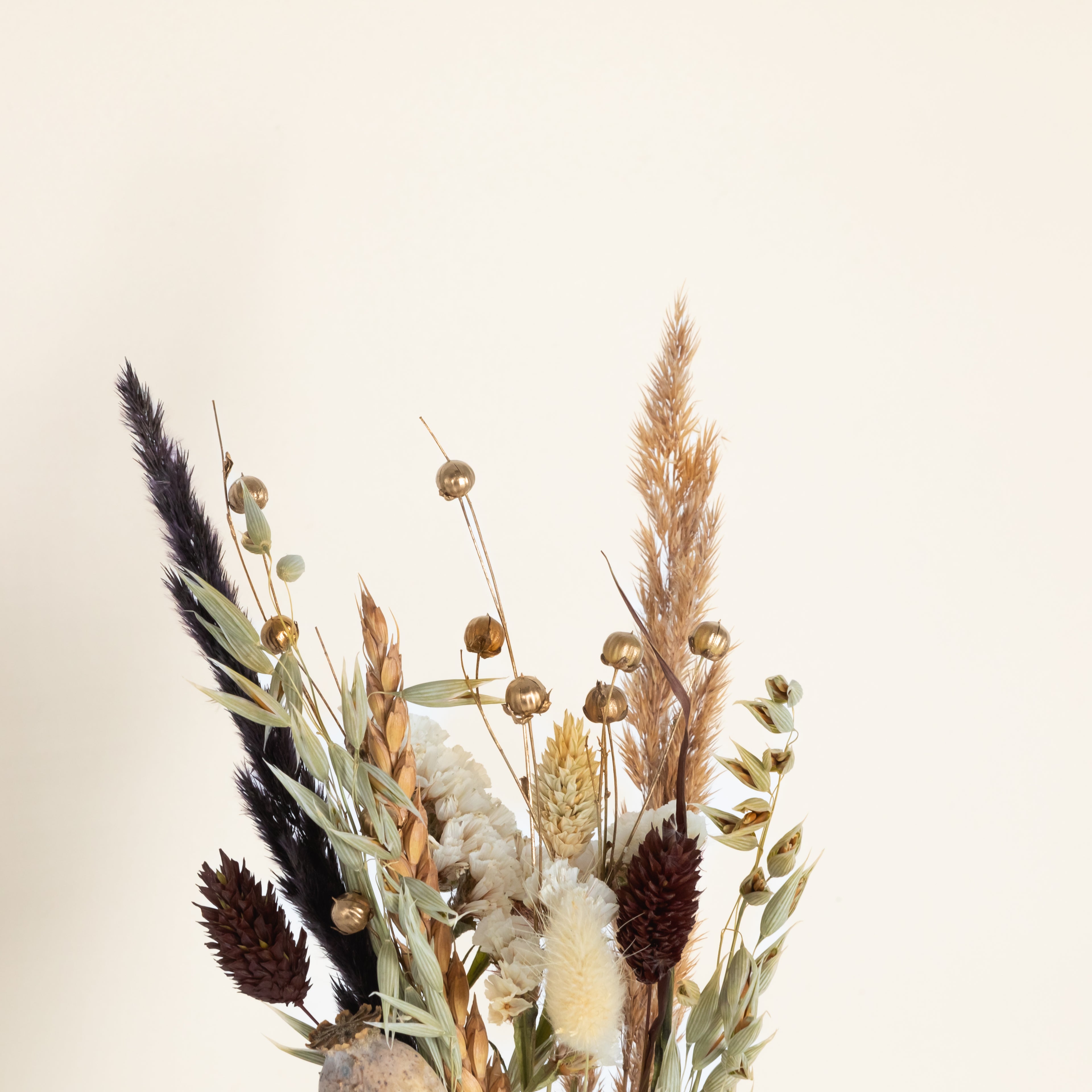 Trockenblumenstrauß in schwarzer Glasvase