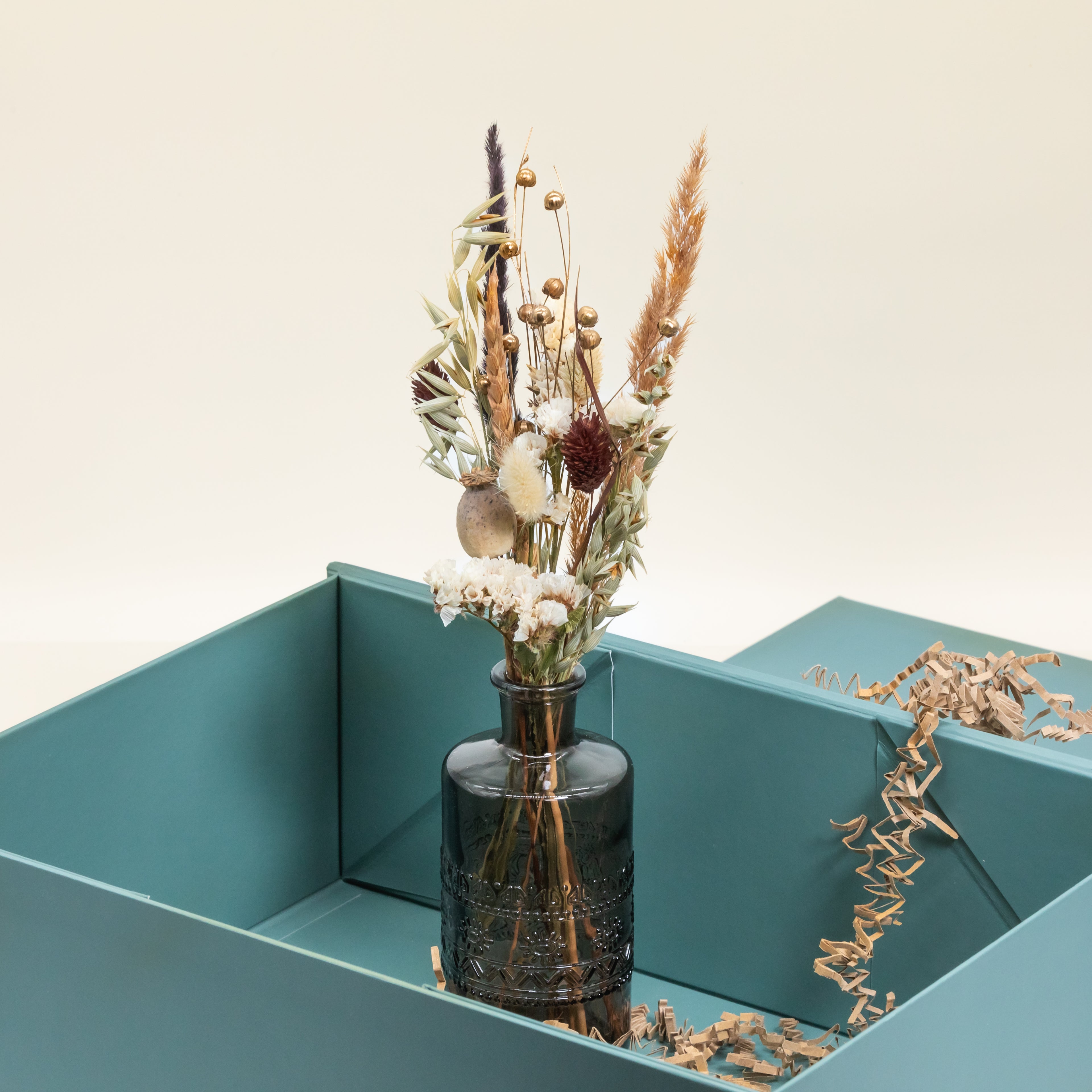 Trockenblumenstrauß in schwarzer Glasvase